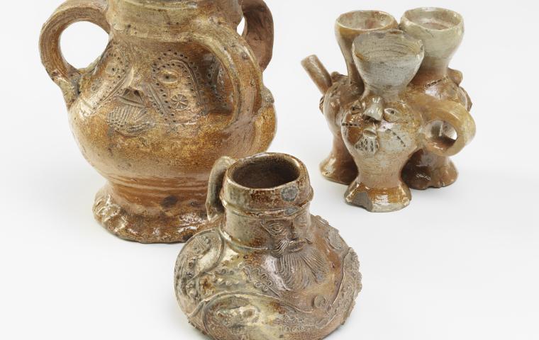 Une collection de cruches en faïence ornées de visages humains.
