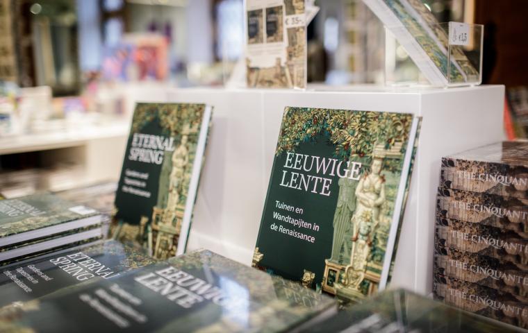 Een stapel boeken met de titel "Eeuwige Lente" liggen op een schap.