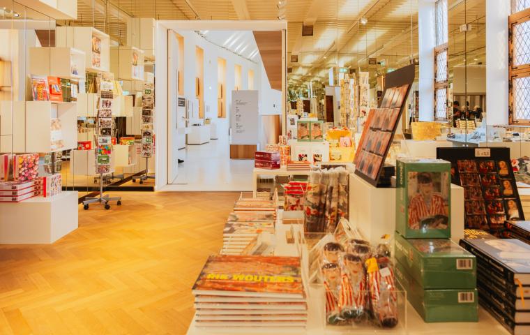 Een kamer gevuld met lage tafels en schappen, vol boeken en andere producten.