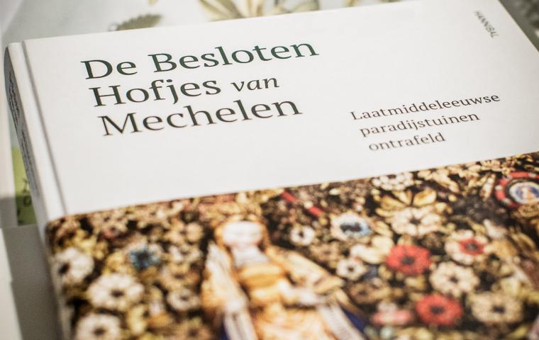 Een hardcover boek met de titel "De Besloten Hofjes van Mechelen".
