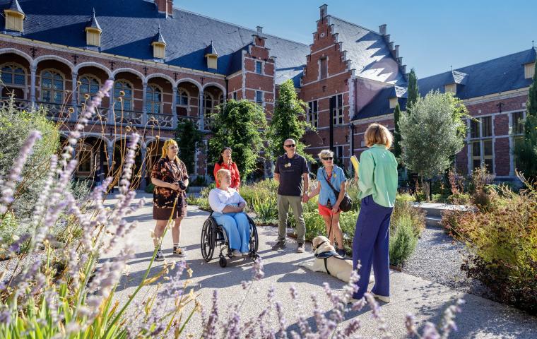 Le guide donne des explications à un groupe dans le jardin du Hof van Busleyden.