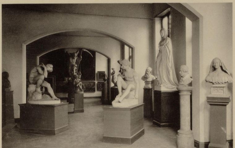Photo en noir et blanc de sculptures dans une ancienne salle de musée.