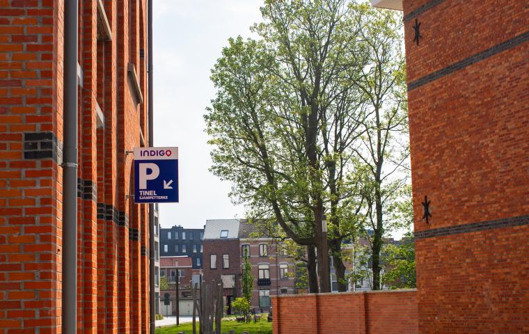 Parkingbord hangt aan de buitenkant van roodoranje bakstenen huis
