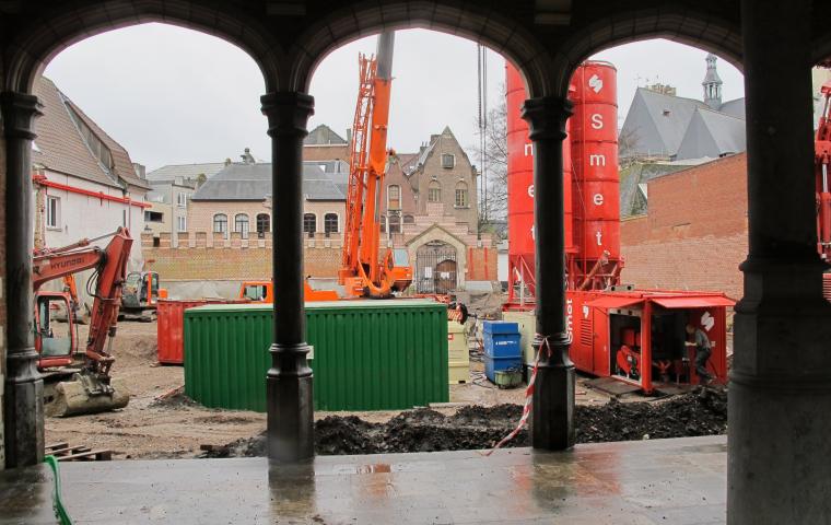 On aperçoit un chantier derrière une rangée de colonnes.