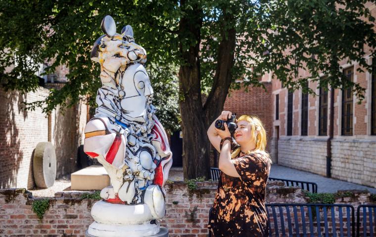 Bezoeker neemt foto van standbeeld in de tuinen