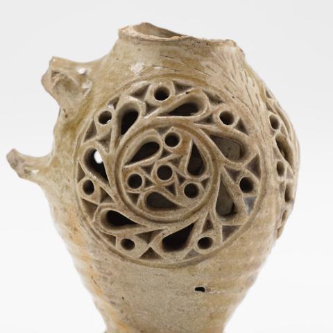Un vieux vase à l'anse cassée et au décor complexe.