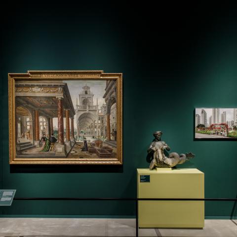 Een groene museummuur met schilderij, foto en sculptuur.