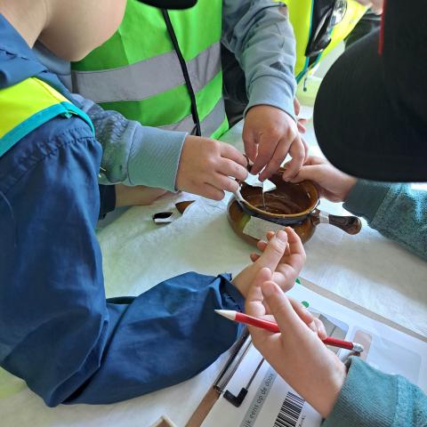 Kinderen puzzelen een gebroken archeologisch object terug samen.