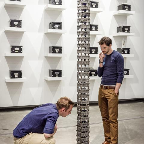 Twee bezoekers kijken naar een soort paal gemaakt uit metalen raster.