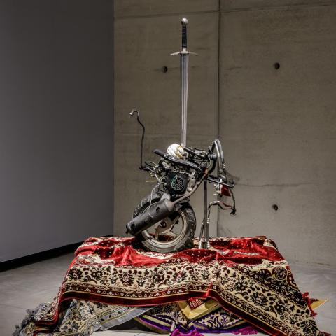 Een hedendaags kunstwerk gemaakt uit tapijten en een zwaard.