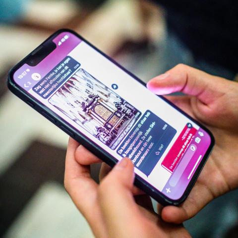 Nahaufnahme von Händen, die ein Smartphone halten.