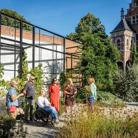 Gids geeft uitleg aan groep in de tuin van het Hof van Busleyden.