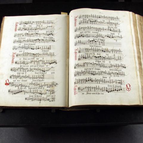 Een groot boek met muziek notatie ligt opengeslagen.